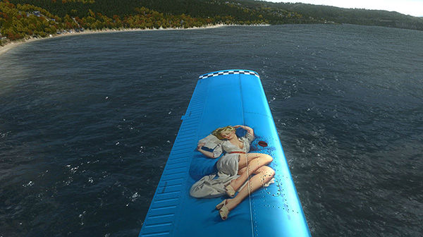 Aerial view of a large body of water with a wing of a plane visible in the frame.