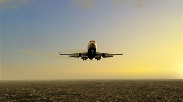 A large jet airplane flying over a city skyline.