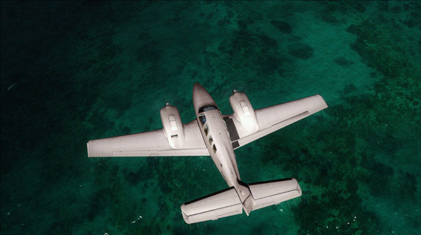 An airplane flying high above coral waters.