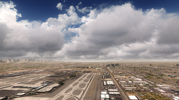 Aerial view of KPHX airport with clouds and buildings in the background.