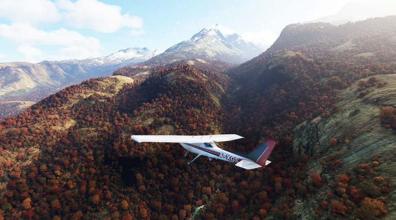 A small airplane soaring above rugged mountain landscape.