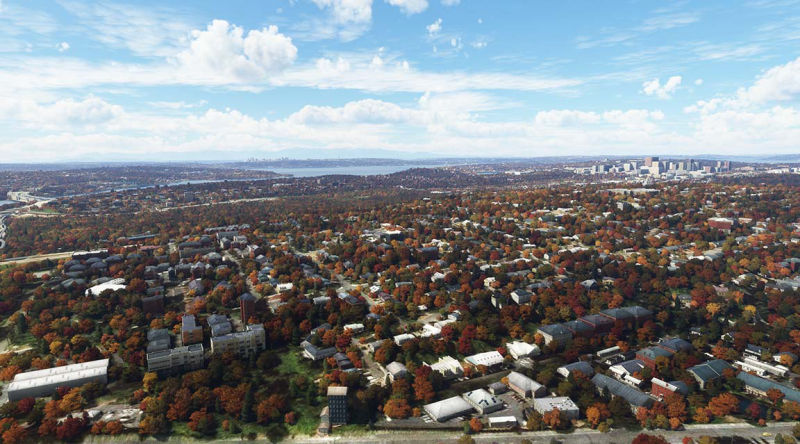 Urban area with autumn trees and structures during cloudy weather.
