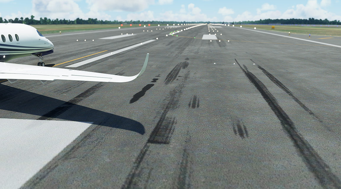Airplane on runway with runway marker in foreground.