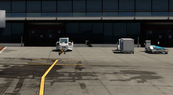 A busy airport with multiple vehicles parked in front of it.