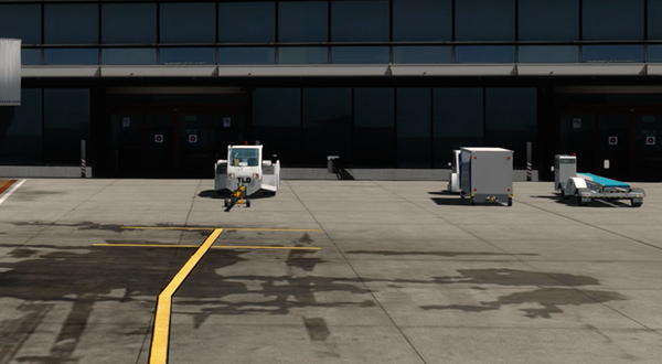 A busy airport with multiple vehicles parked in front of it.