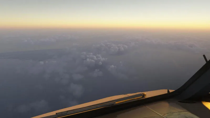Golden-hour view over the wing above a soft layer of clouds, REX Atmos CORE atmospherics in Microsoft Flight Simulator 2024