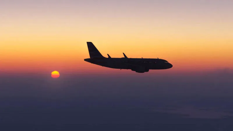 Airliner silhouetted against a vivid orange sunset, REX Atmos CORE sky colors in Microsoft Flight Simulator 2024