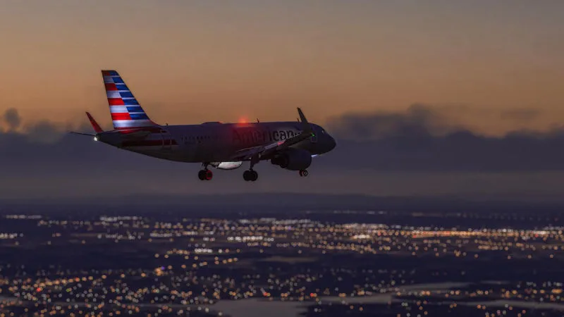 American Airlines Airbus A320 on approach at dusk over city lights, REX Atmos CORE in Microsoft Flight Simulator 2024