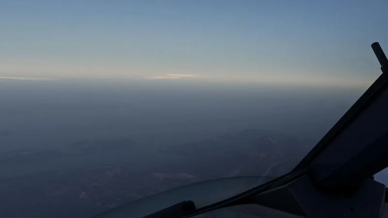 Hazy high-altitude dusk view over a distant coastline, REX Atmos CORE atmospheric haze in Microsoft Flight Simulator 2024