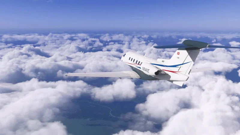 Private business jet cruising above cumulus clouds along a coastline, REX Atmos CORE in Microsoft Flight Simulator 2024
