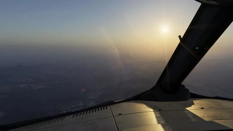 Hazy sunlit horizon over the wing with realistic atmospheric scattering and lens flare, REX Atmos CORE in Microsoft Flight Simulator 2024