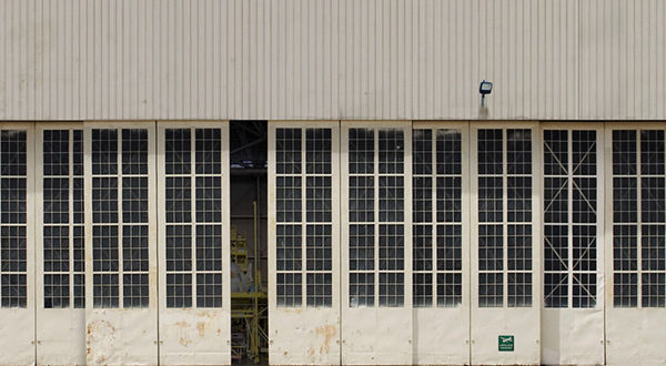 An airport hangar door partially open.