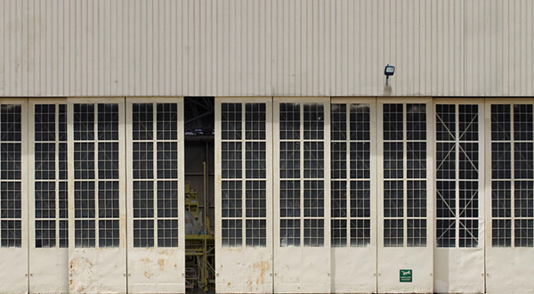 An airport hangar door partially open.