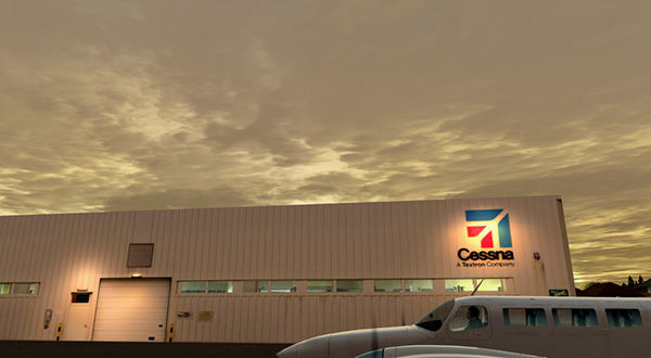 A white building with red trim, labeled "Cessna Airport hangar".