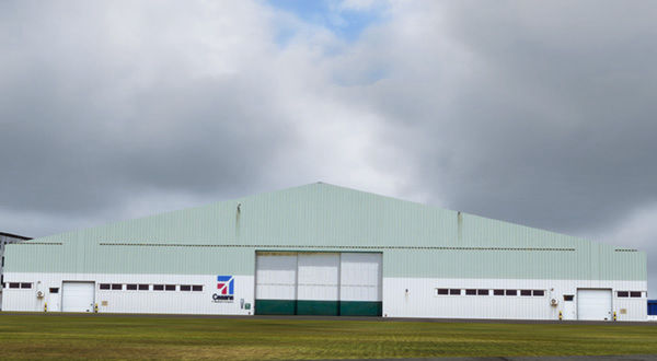Cessna Airport hangar with a prominent white building in the background.