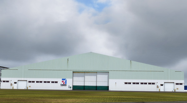 Cessna Airport hangar with a prominent white building in the background.