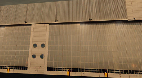 A large airport hangar with a large window on the side.