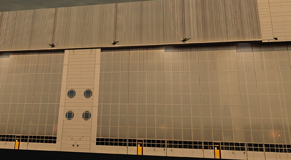 A large airport hangar with a large window on the side.