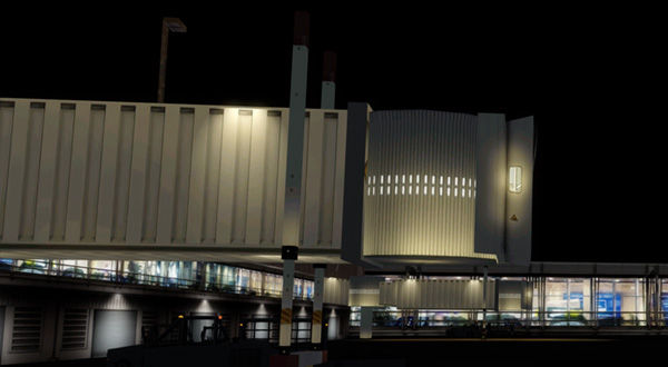 A night view of an airport terminal with a jetway.